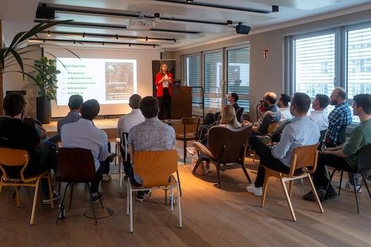 Eine Mitarbeiterin der codecentric AG hält im Office Frankfurt einen Vortrag und steht vor Publikum