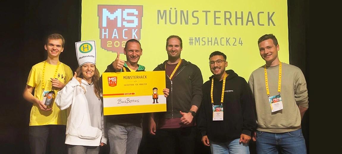Ein codecentric Team steht bei einem Hackathon auf der Bühne und erhält einen Preis für die App-Idee "BusBonus".