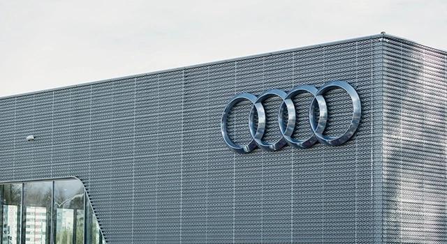 An exterior view of an Audi factory with a large Audi logo.